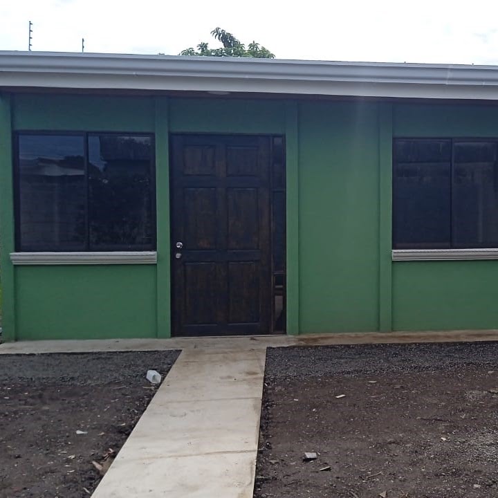 Casa terminada, fachada verde, construida por Construeza Modular CR
